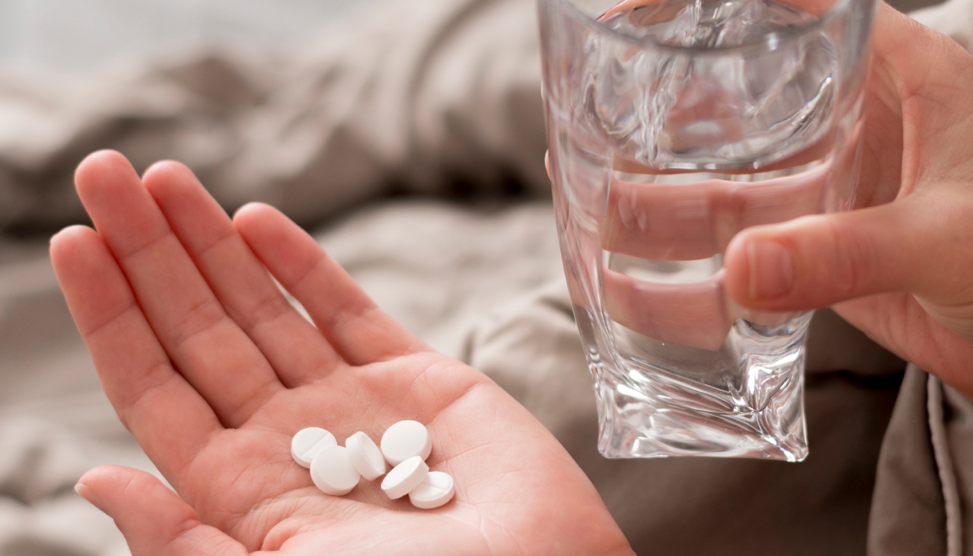 Pessoa tomando medicamentos (Crédito: Freepik)
